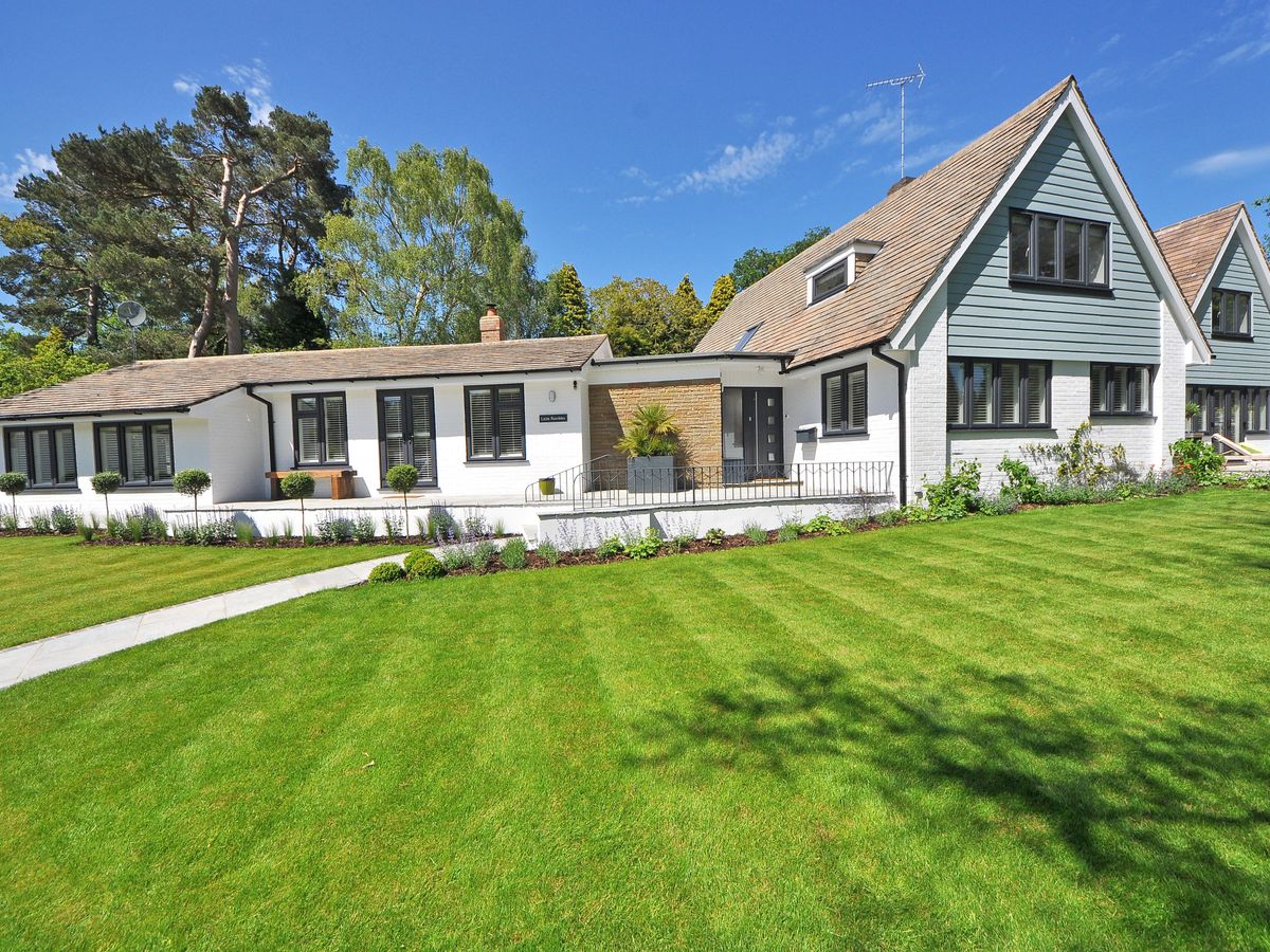 Well-kept residential lawn with planting beds and mature trees
